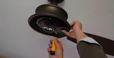 Electrician installing ceiling fan mounting bracket and fixture in Harrisburg, PA