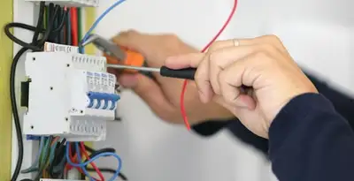 Electrician installing and adjusting circuit breakers in an electrical panel in Harrisburg, PA