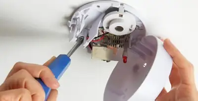 Certified technician wiring smoke detector during installation in Harrisburg, PA
